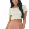 She + Sky Tops Ecru Off The Shoulder Smocked Crop Top With Ruffle Details 1 She + Sky Tops Ecru Off The Shoulder Smocked Crop Top With Ruffle Details